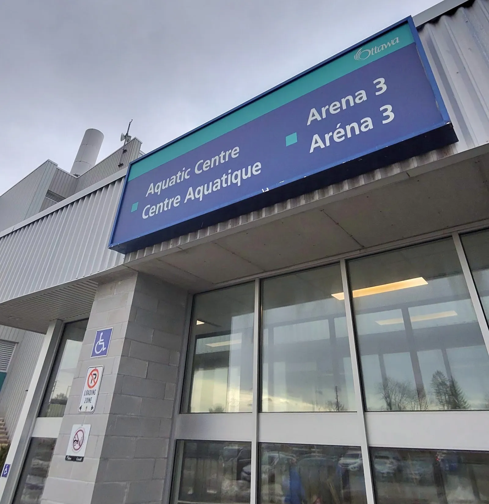 A Nepean Sportsplex entrance on Woodroffe Avenue in Ottawa, under the City sign for the Aquatic Centre and Arena 3 — Nepean Sportsplex