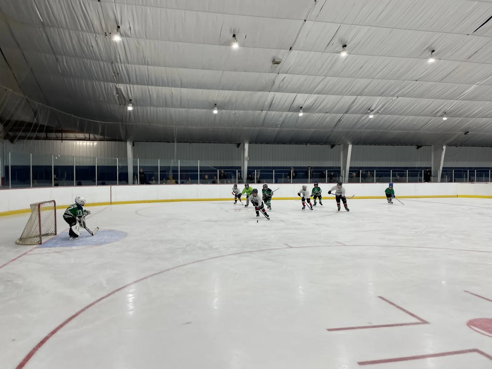 The New Hartford rink during a youth practice, under a white fabric ceiling with glass along the far boards. — New Hartford Recreation Center