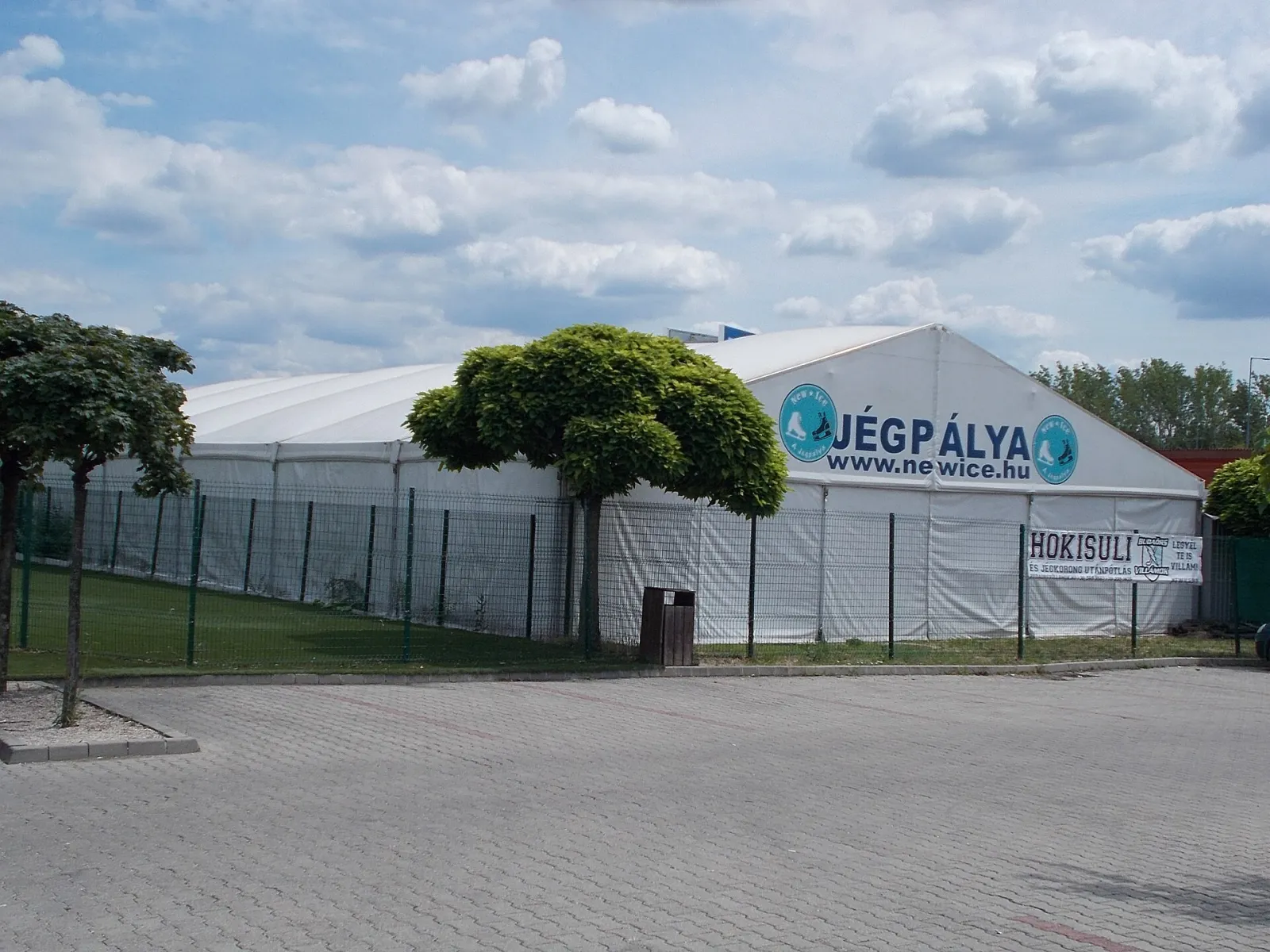 A New Ice jégpálya fehér sátorcsarnoka JÉGPÁLYA felirattal Budaörsön, a parkolóból nézve – New Ice Jégpálya