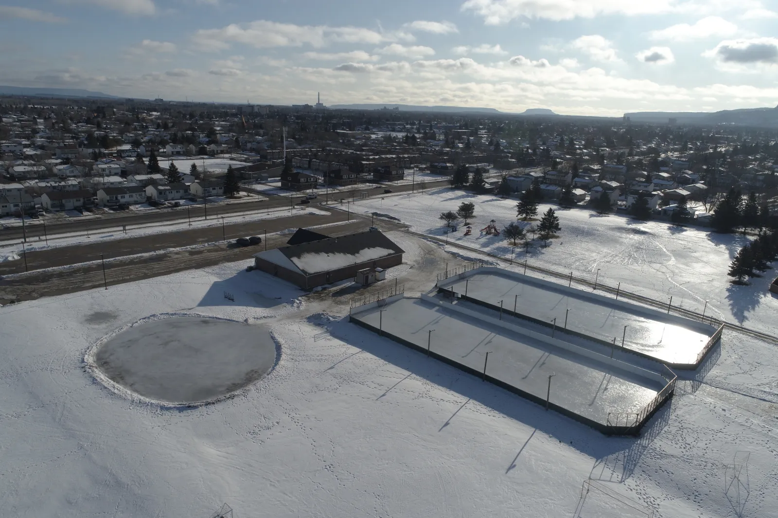 Vista aérea de Northwood Playfield con la caseta, las pistas con vallas y el estanque de patinaje — Northwood Playfield Outdoor Rinks