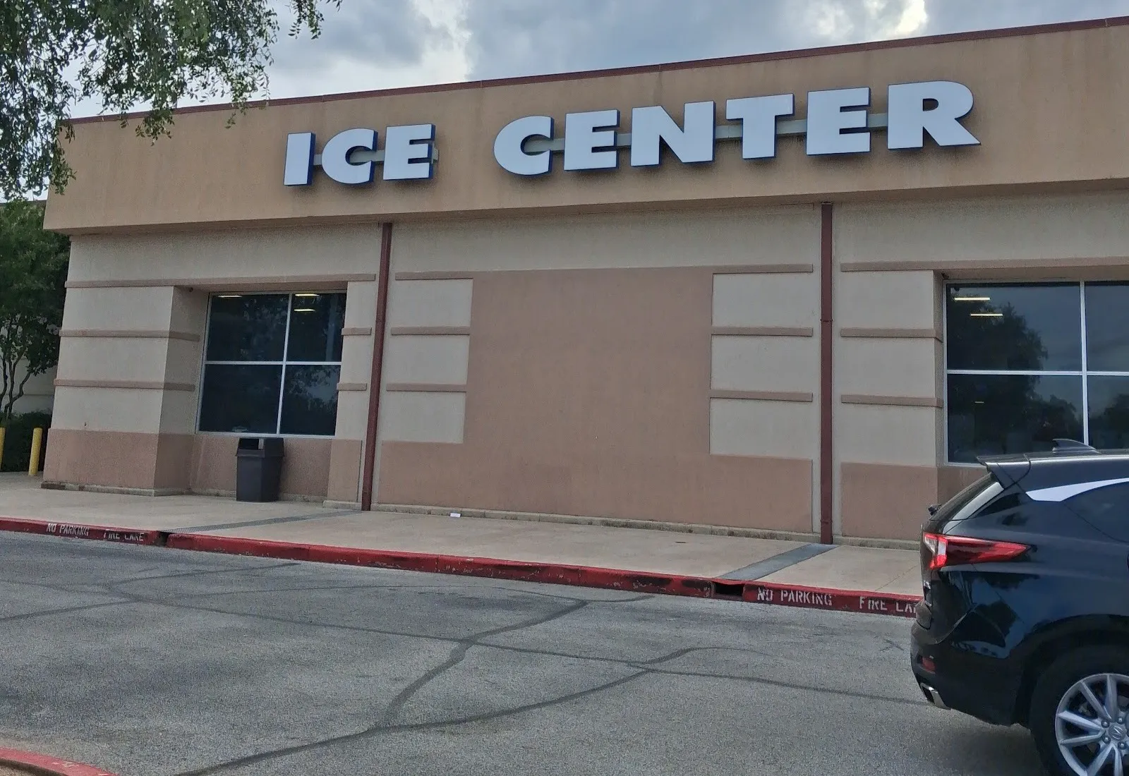 The Ice Center wing at Northwoods, a tan stucco block with large Ice Center letters along the roofline above its windows — Ice & Golf Center at Northwoods