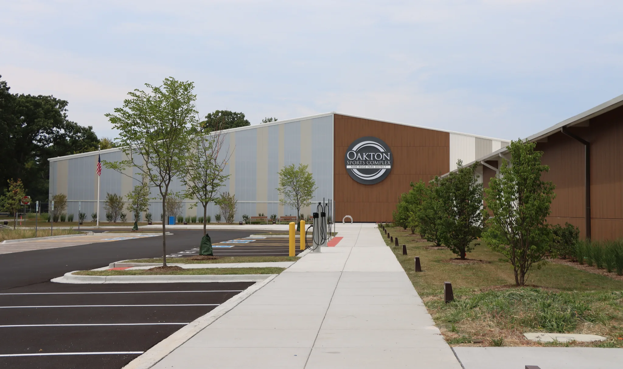 Metal-panel frontage and the wood-clad entry bay from the walkway — Oakton Sports Complex (Park Ridge)