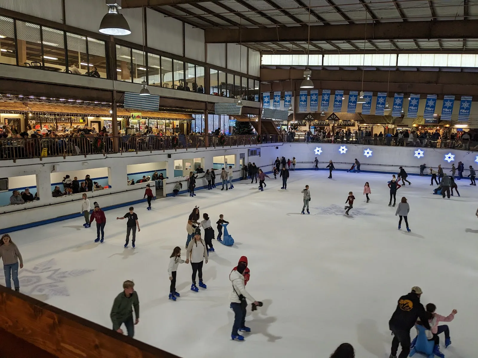The indoor ice rink at Ober Gatlinburg with skaters at a distance and the mezzanine above — Ober Gatlinburg Ice Arena