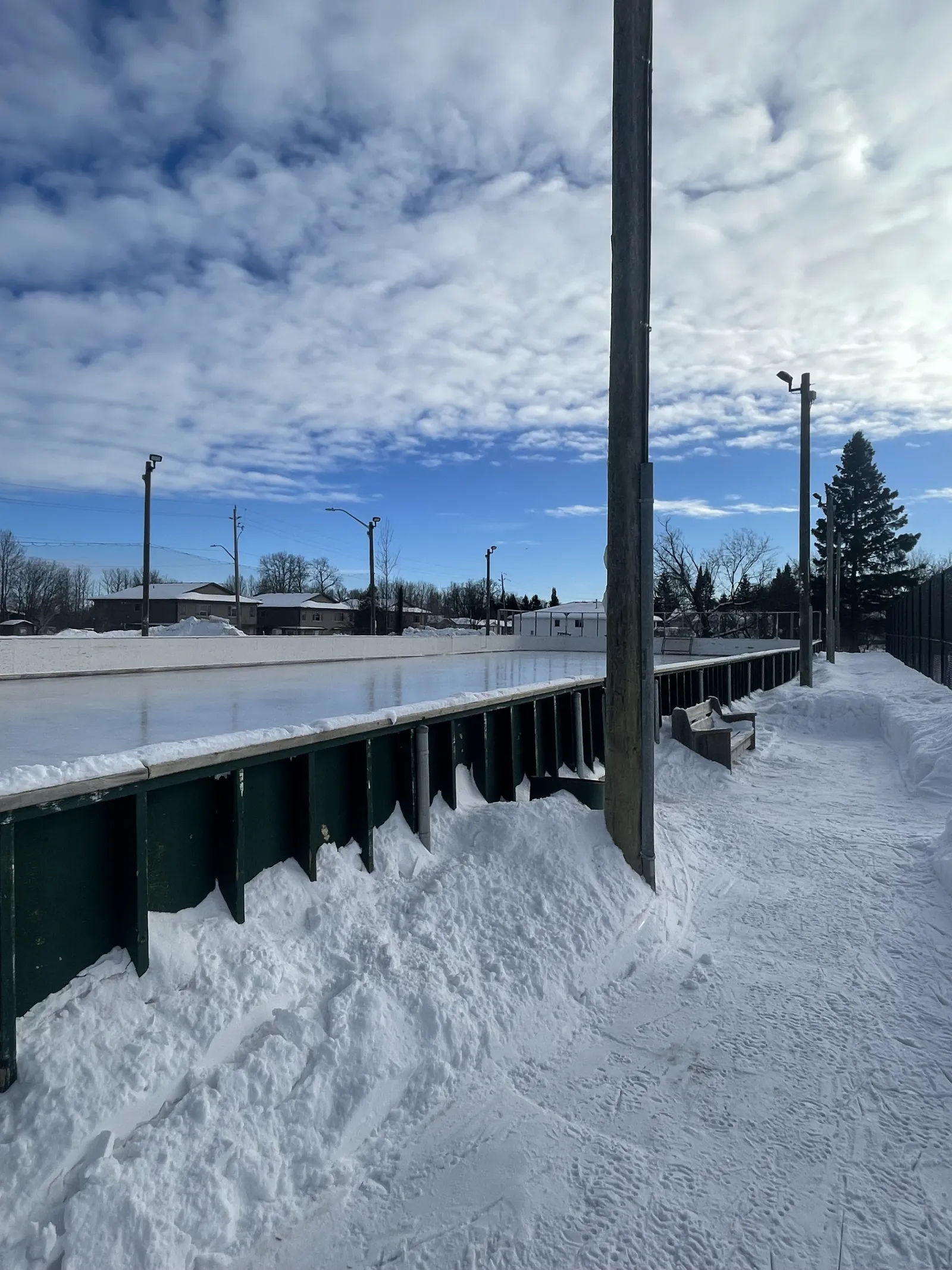 Vallas verde oscuro y postes de luz a lo largo de la pista del Oliver Road Community Centre — Oliver Road Community Centre Outdoor Rink