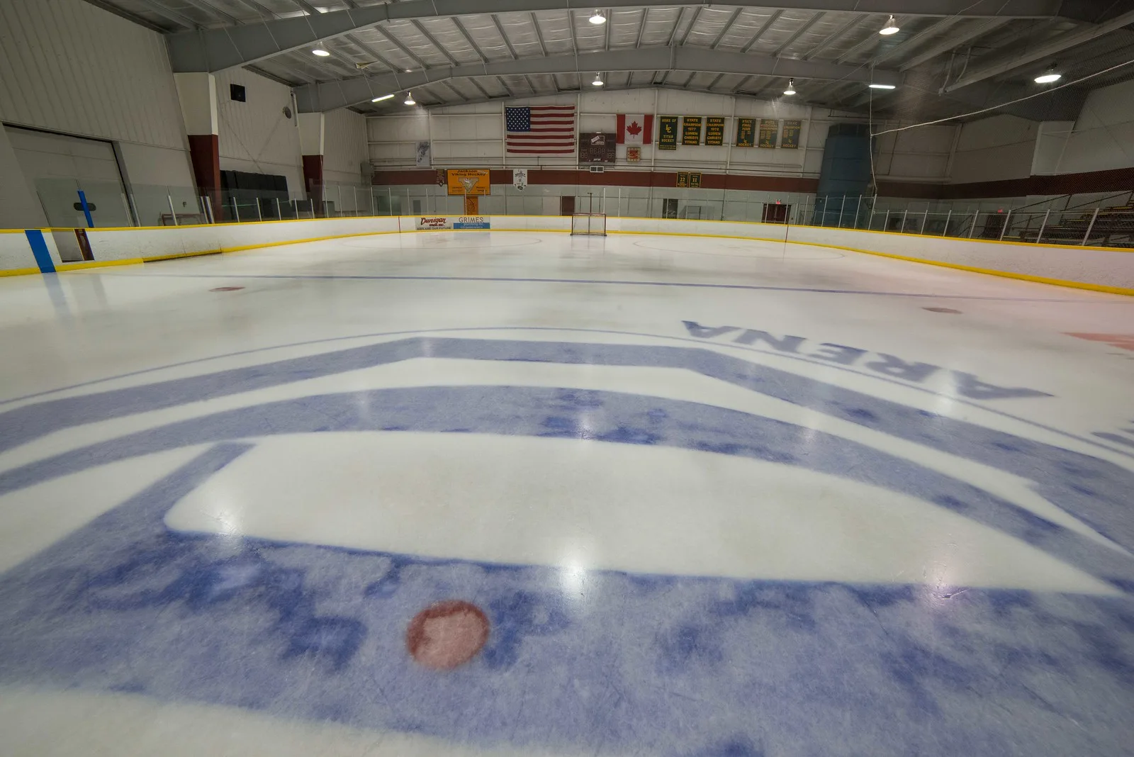 Casi toda la pista desde el nivel del hielo en un extremo, vacía — Optimist Ice Arena