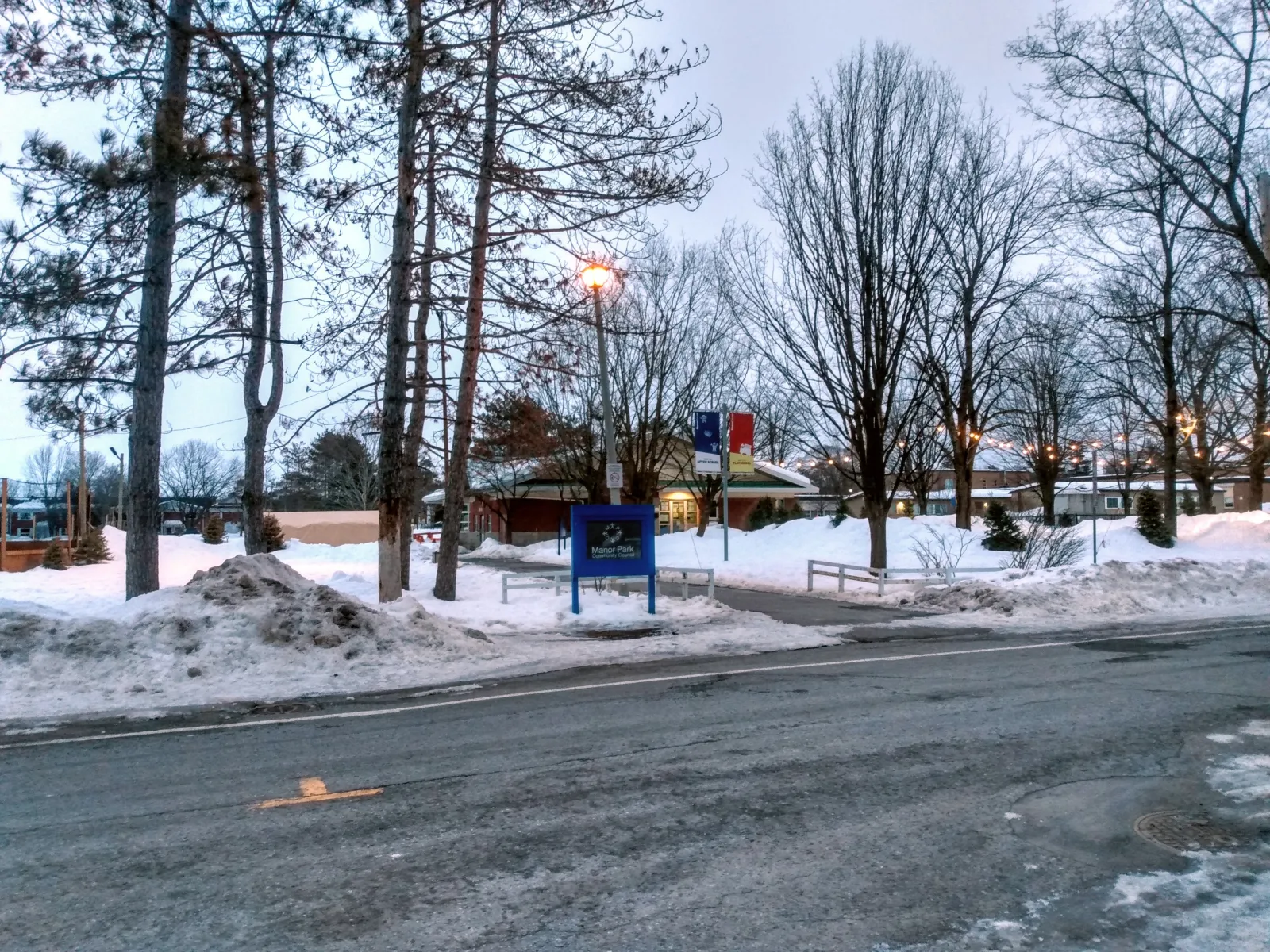 The Manor Park Community Council building at 100 Braemar Street in winter, snow banked along the walkway, with the community council sign in front. — Manor Park Outdoor Rink