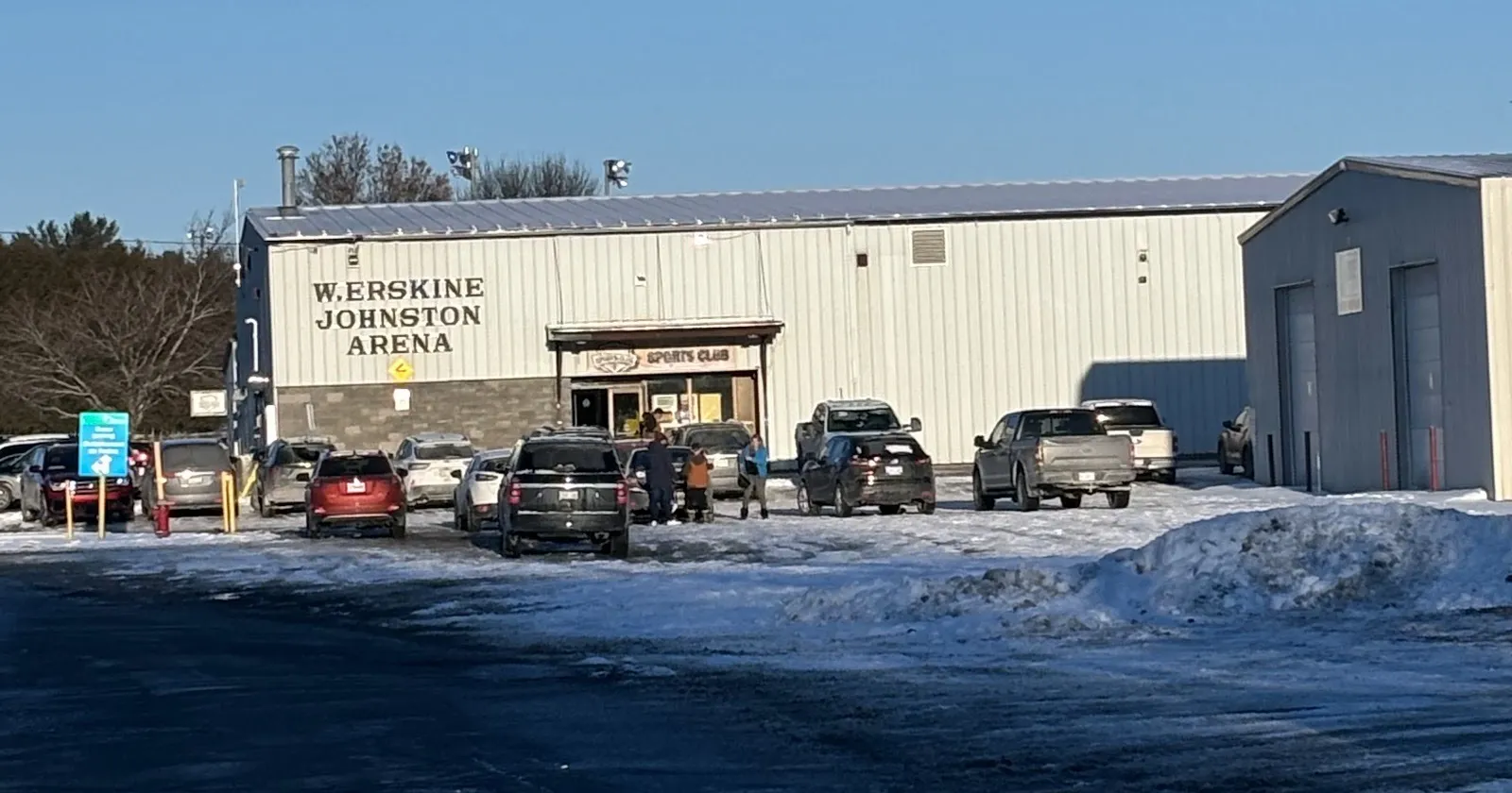 The W. Erskine Johnston Arena on Carp Road in Carp on a clear winter day, with its painted name on the front wall — W. Erskine Johnston Arena