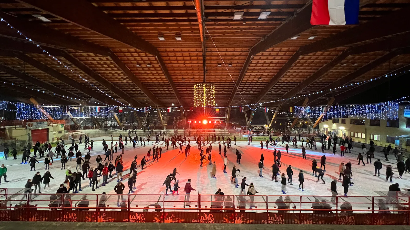 Una serata di pattinaggio pubblico al PalaFeltre, con la folla di pattinatori sotto il tetto di legno e le luci colorate – PalaFeltre