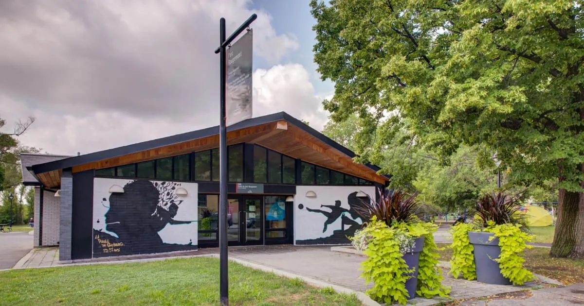 Le chalet du parc Rougemont, avec ses fenêtres ornées d’une murale, près du sentier du parc, où l’on se réchauffe en hiver (photo de la Ville de Montréal) — Parc Rougemont Outdoor Rink