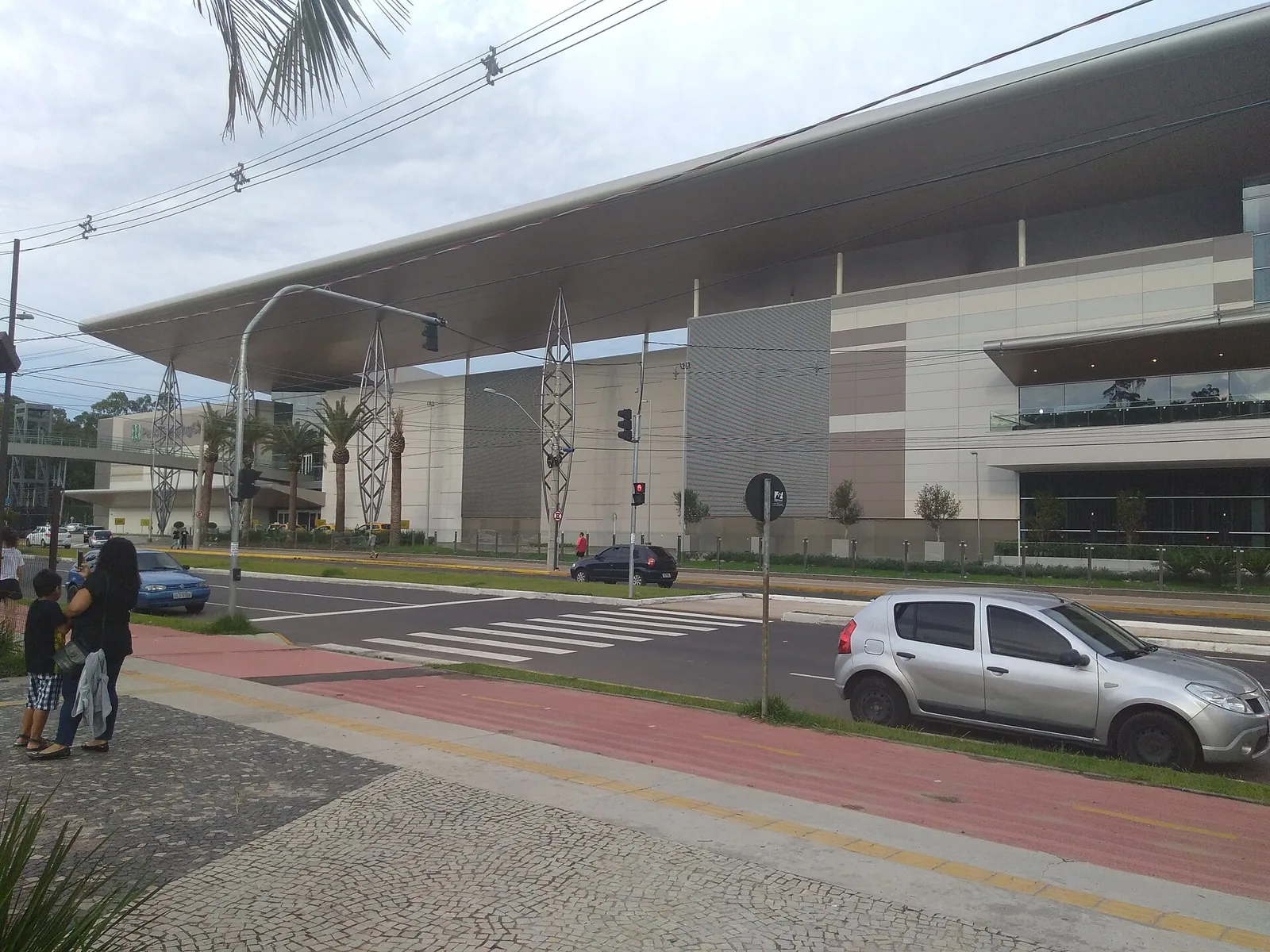 A longa fachada do ParkShopping Canoas voltada para a rua, com sua ampla cobertura projetada e a entrada envidraçada. — ParkShopping Canoas Ice Rink
