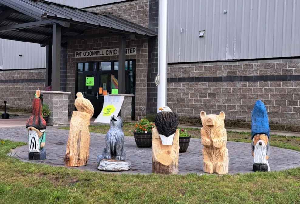 The entrance of the Pat O'Donnell Civic Center in Ironwood, with chainsaw-carved wooden figures in front of the doors — Pat O'Donnell Civic Center