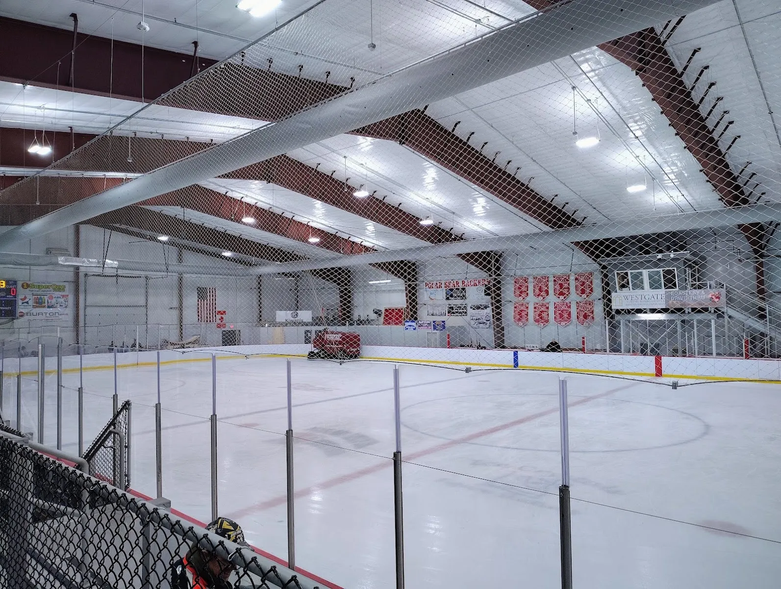 The empty ice sheet at the Pat O'Donnell Civic Center in Ironwood, with netting over the boards and the stands beyond — Pat O'Donnell Civic Center