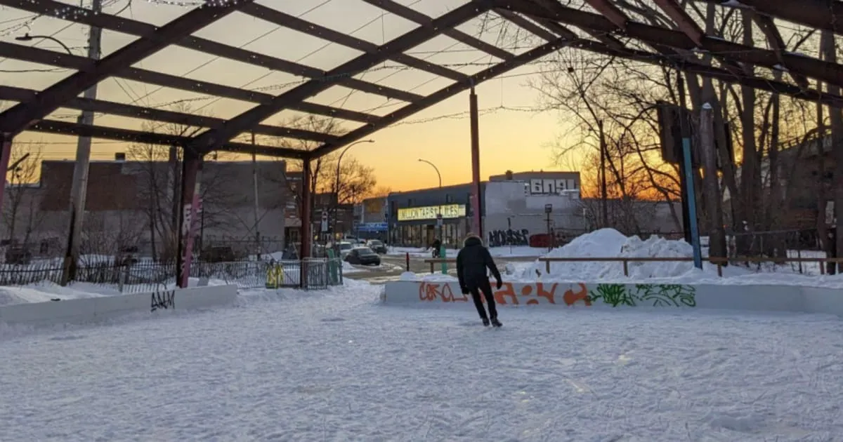 La patinoire extérieure couverte de Bernard Est au crépuscule, avec une glace enneigée, un patineur seul et la charpente d’acier du toit au-dessus (photo de la Ville de Montréal) — Patinoire Bernard Est