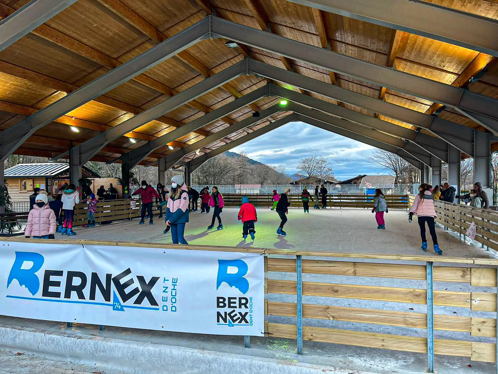 La charpente en bois et la bande de la patinoire de Bernex, vues depuis le bord de la glace — Patinoire de Bernex