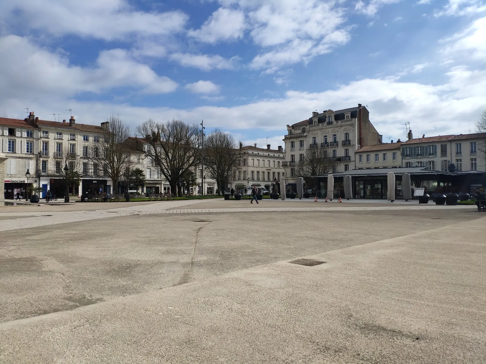 Place Colbert in Rochefort, the wide stone square in the town centre where the Christmas rink is set up, with the old town buildings around it — Patinoire de Noël de Rochefort (place Colbert)