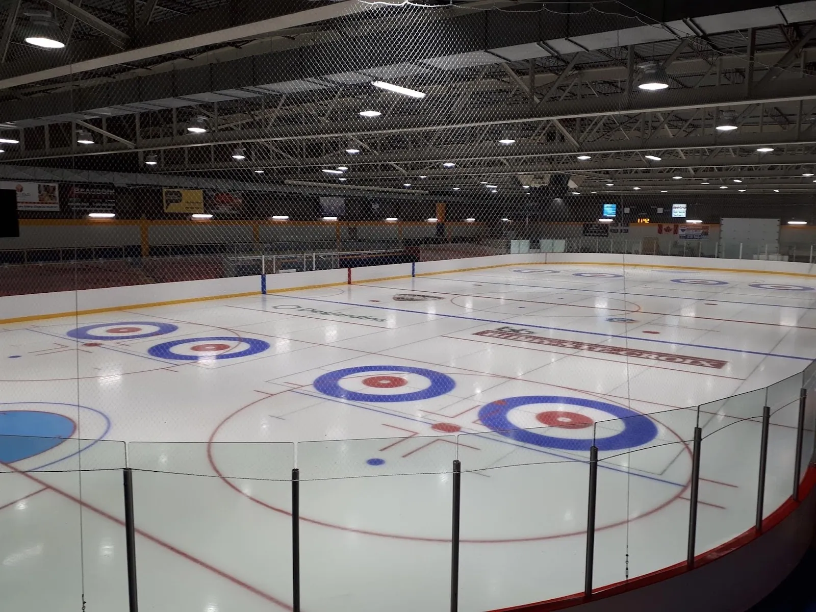 La glace vide de l'aréna du Centre sportif et culturel de Sainte-Croix, avec des cercles de curling peints sur la surface et les bandes tout autour — Patinoire de patin libre de Sainte-Croix