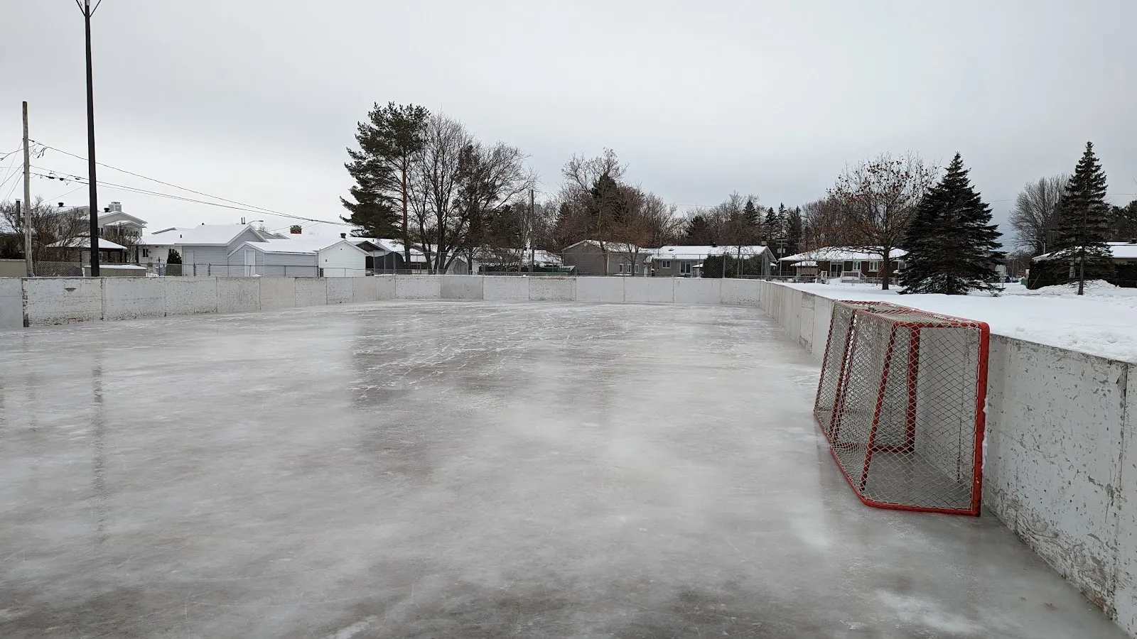 La glace entourée de bandes de la patinoire extérieure du parc d'Anjou à Trois-Rivières, avec un but de hockey contre les bandes — Patinoire du parc d’Anjou