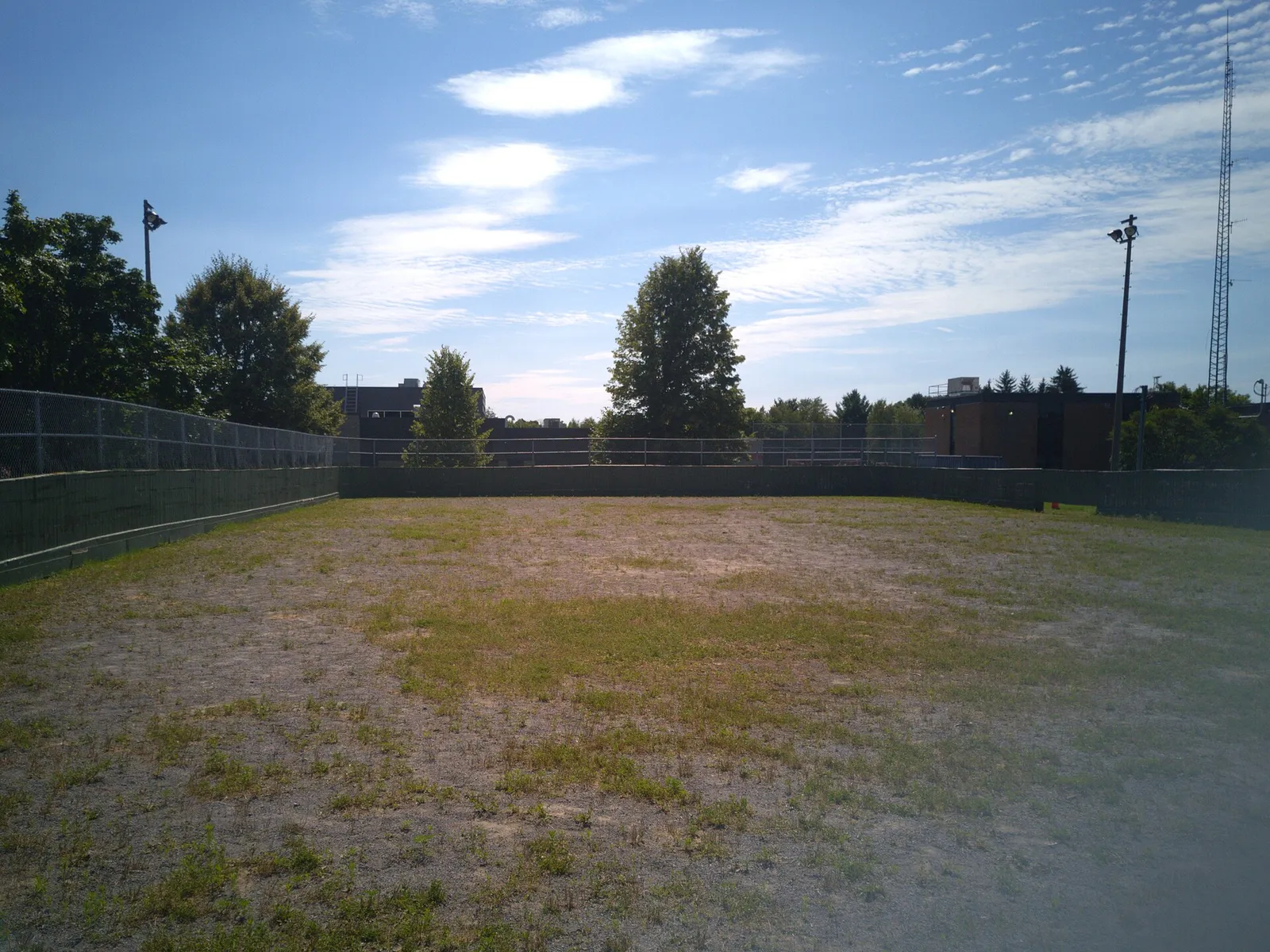 Inside the boards of the Parc des Seigneurs outdoor rink in Trois-Rivières, shown in summer without ice. — Patinoire du parc des Seigneurs