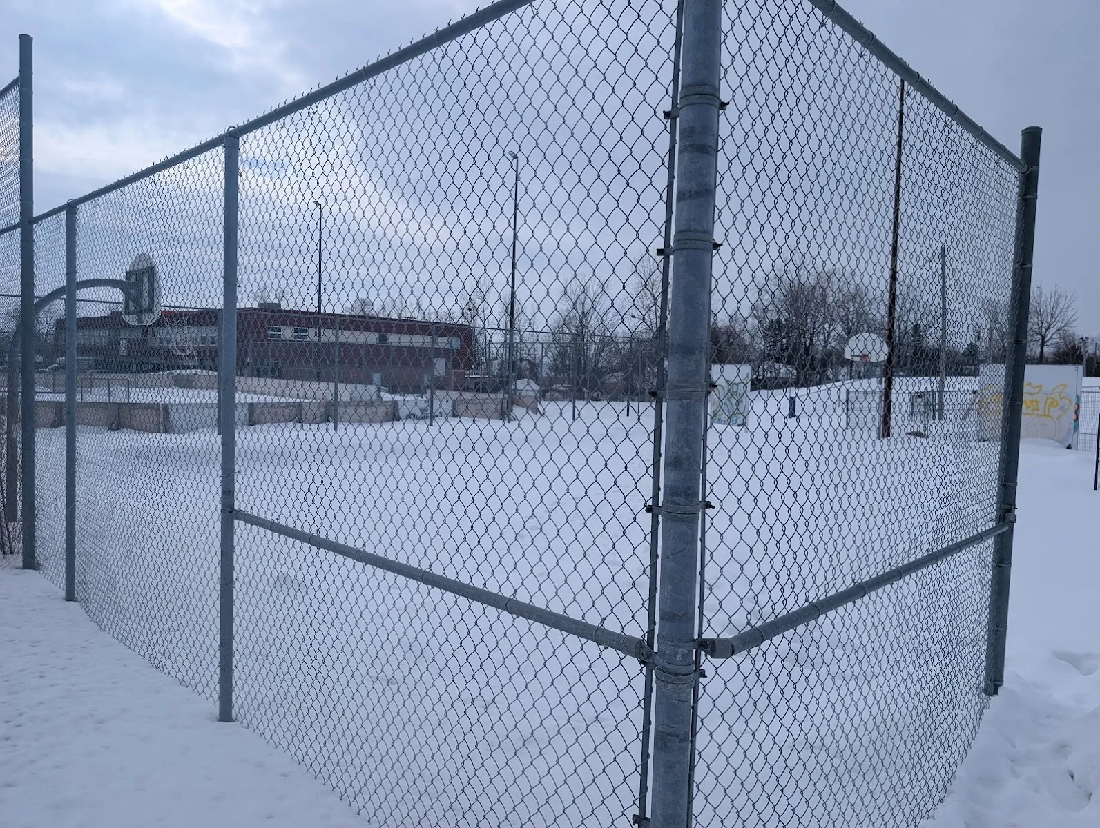 The chain-link fence and boards of the Front Park rink in Aylmer under snow — Patinoire du parc Front (Gatineau)