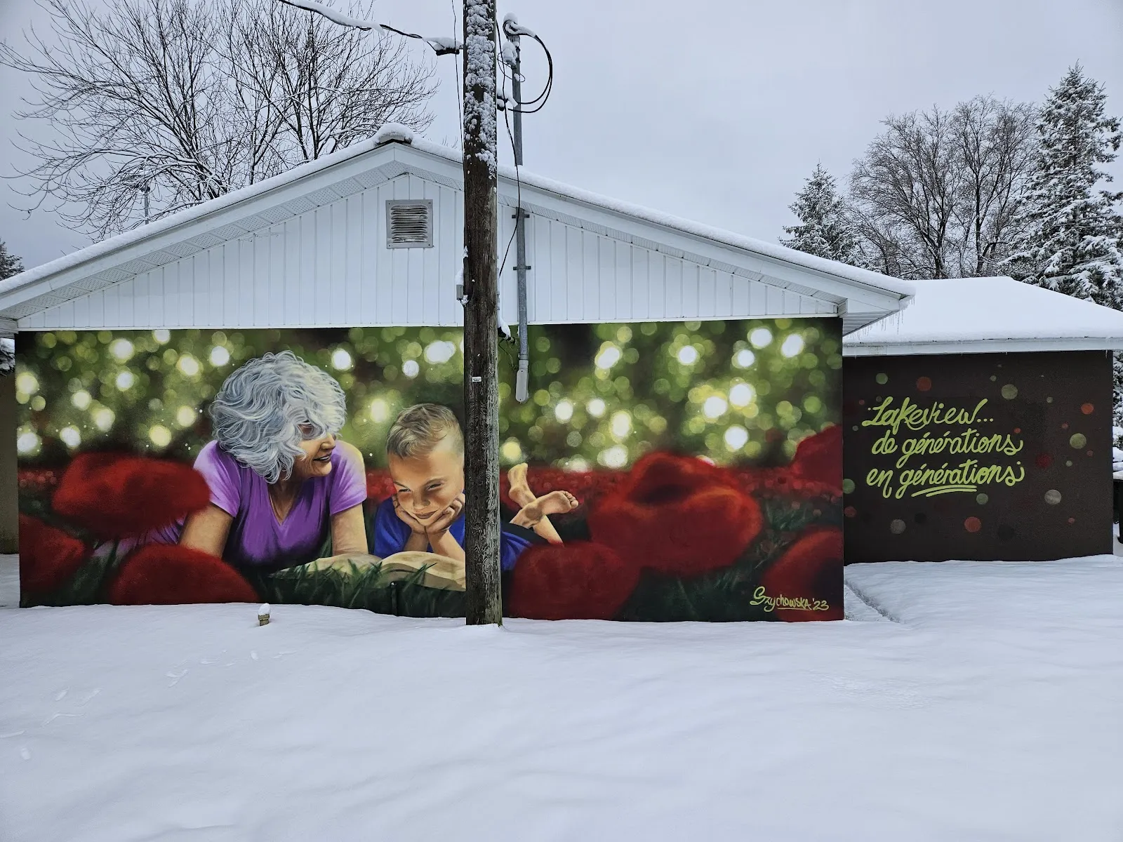 The white park building at Parc Lakeview in Gatineau with a large mural, in winter snow — Patinoire du parc Lakeview (Gatineau)