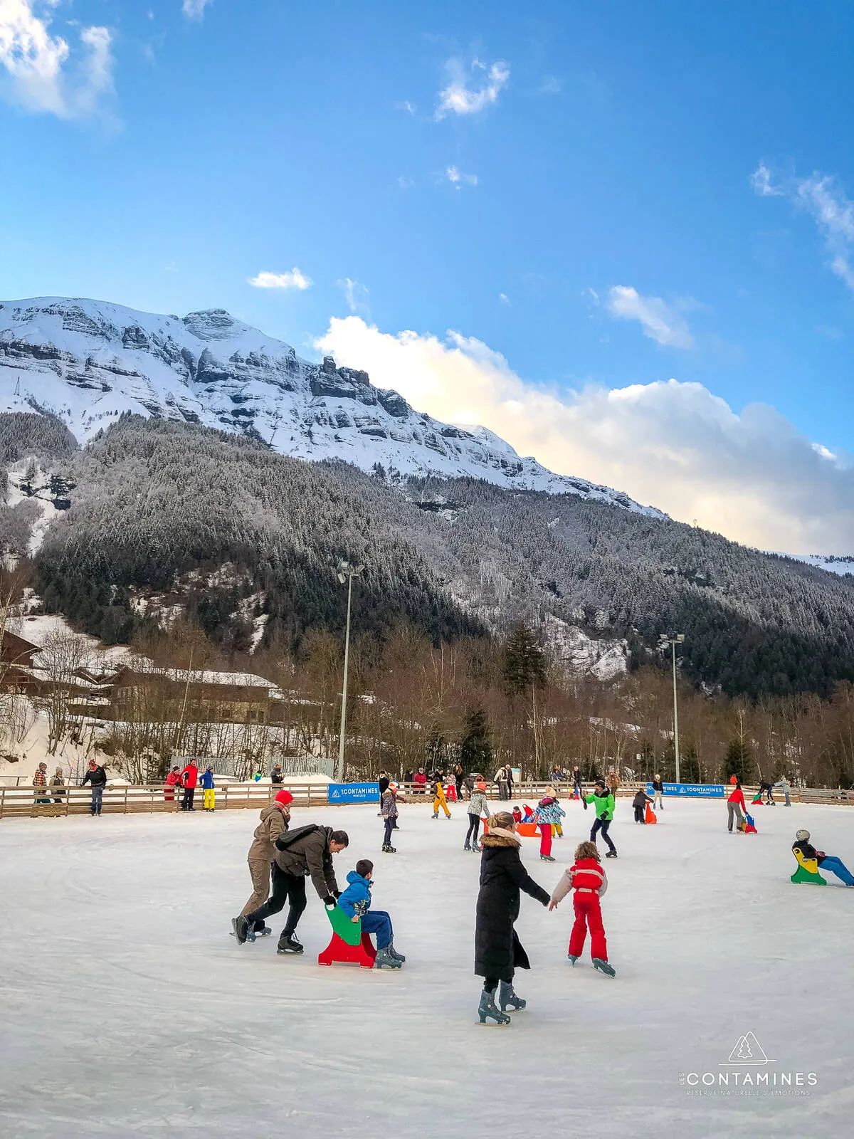 Des patineurs sur la glace en plein air aux Contamines-Montjoie, avec une montagne enneigée derrière. — Patinoire Jean-Christophe Simond (Les Contamines-Montjoie)