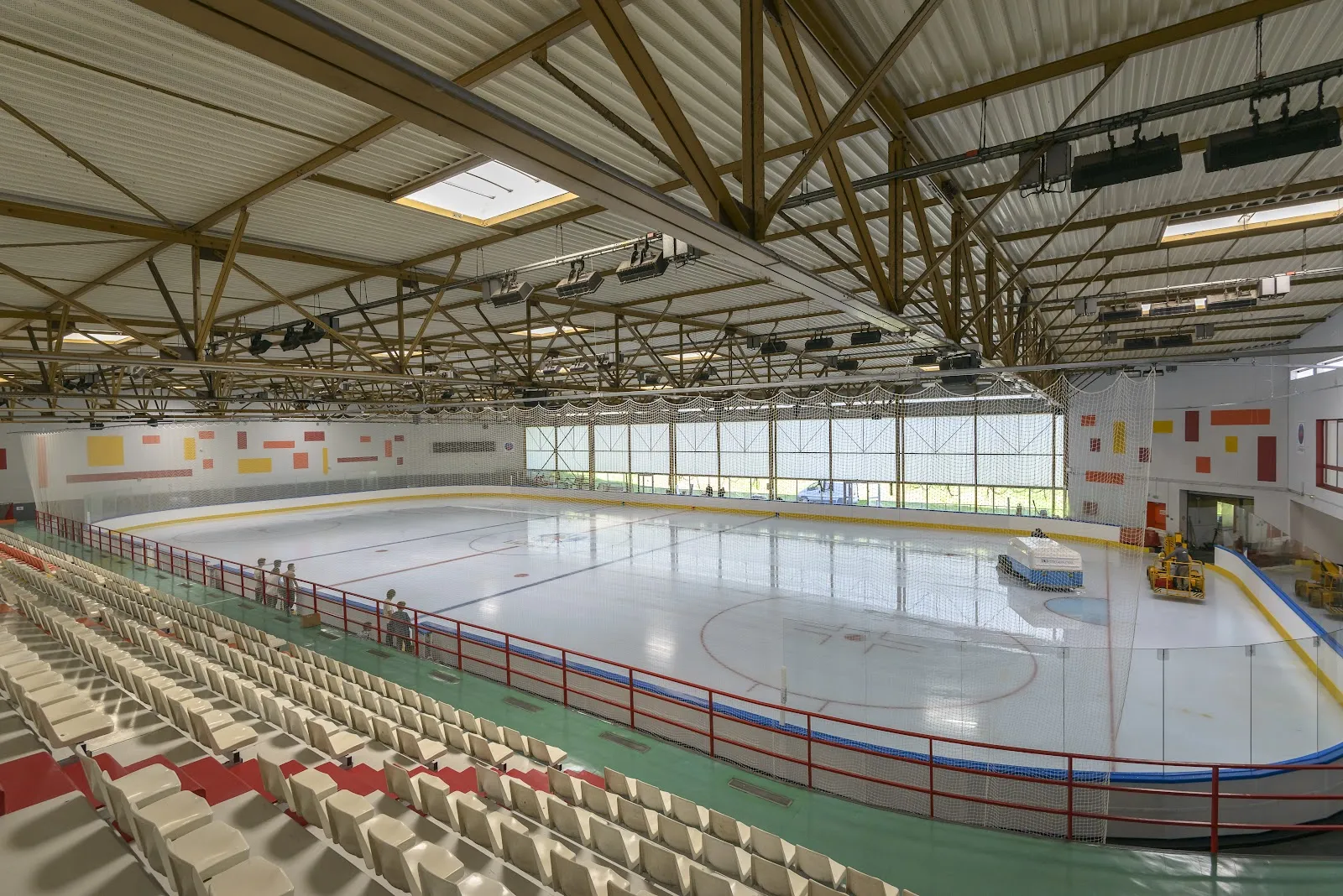 La glace de taille olympique de la patinoire de Limoges vue des gradins fixes, avec la surfaceuse au fond — Patinoire Olympique de Limoges