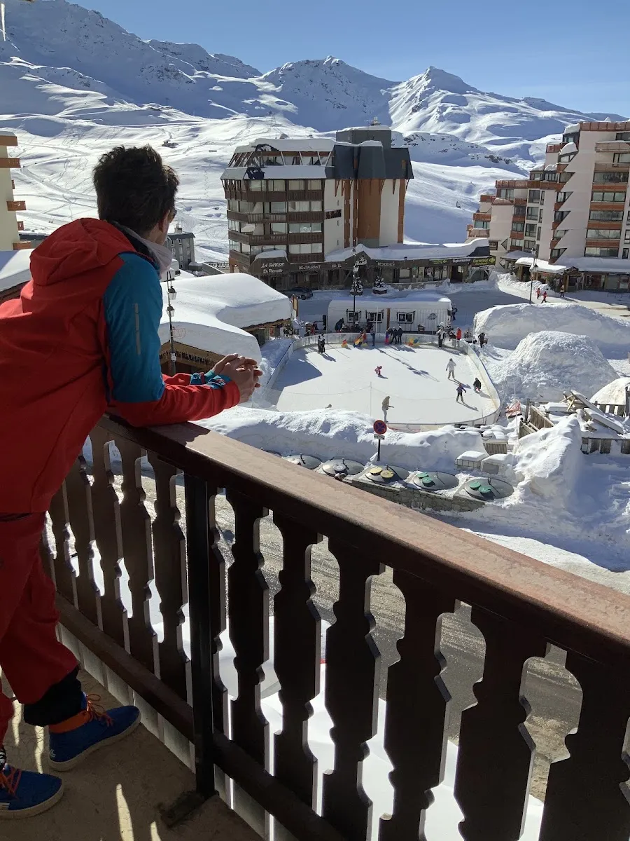 La patinoire de la place Péclet vue d’un balcon, avec les immeubles de Val Thorens et les montagnes en arrière-plan — Patinoire de Val Thorens