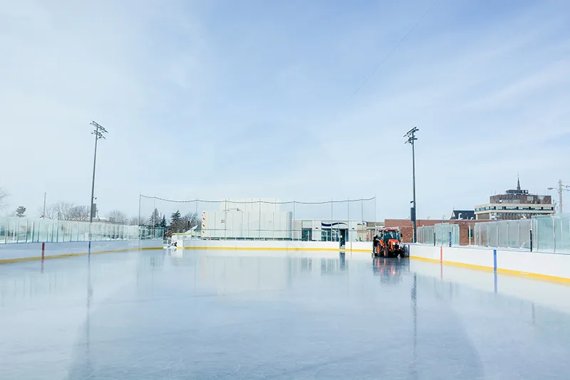 El hielo refrigerado de la Patinoire Victor-Pepin en Drummondville con la máquina alisadora, la cerca y las luces de la pista — Patinoire Victor-Pepin