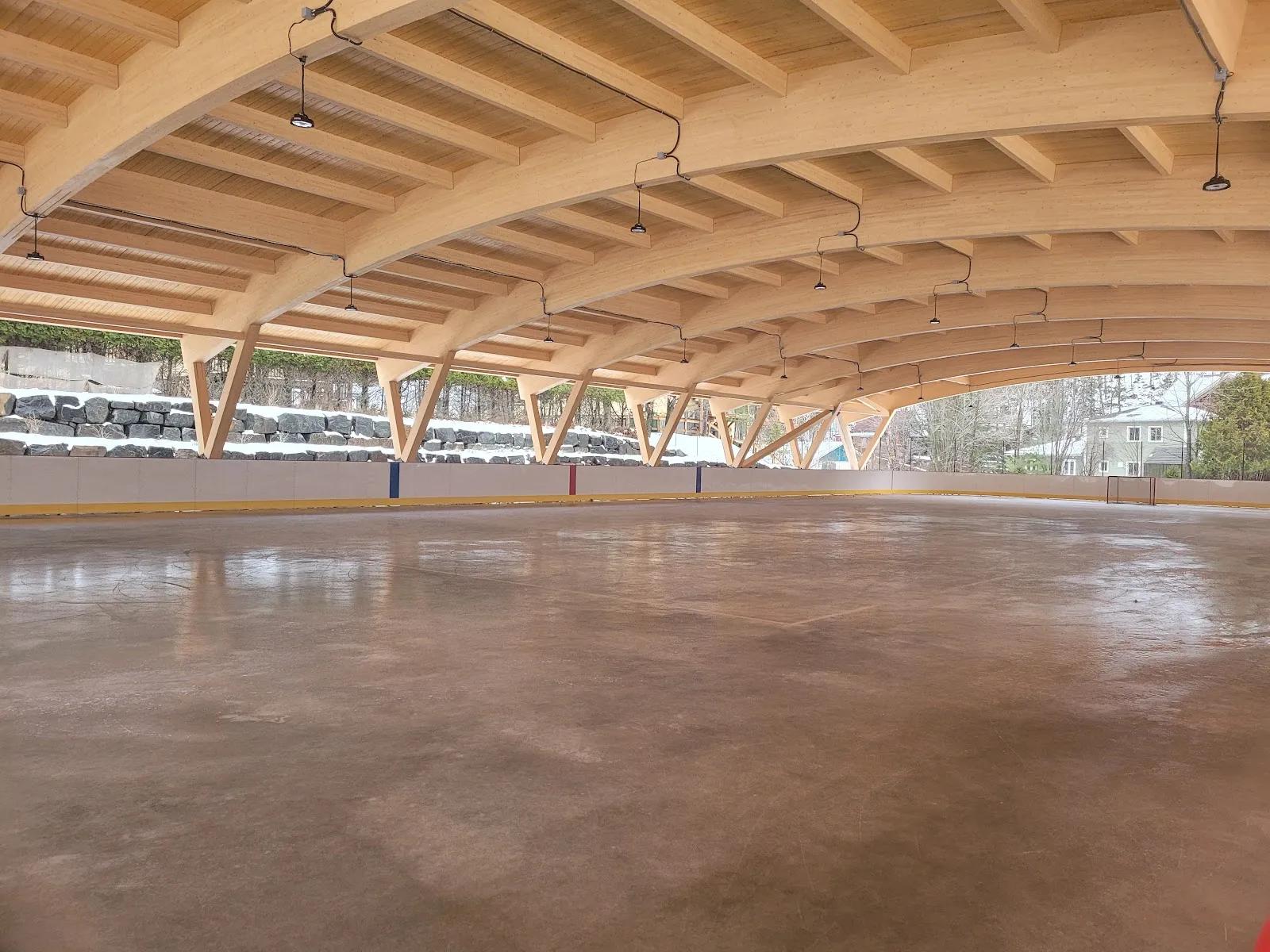 The empty ice sheet under the arched timber roof at Parc Daniel-Lauzon — Patinoires du parc Daniel-Lauzon