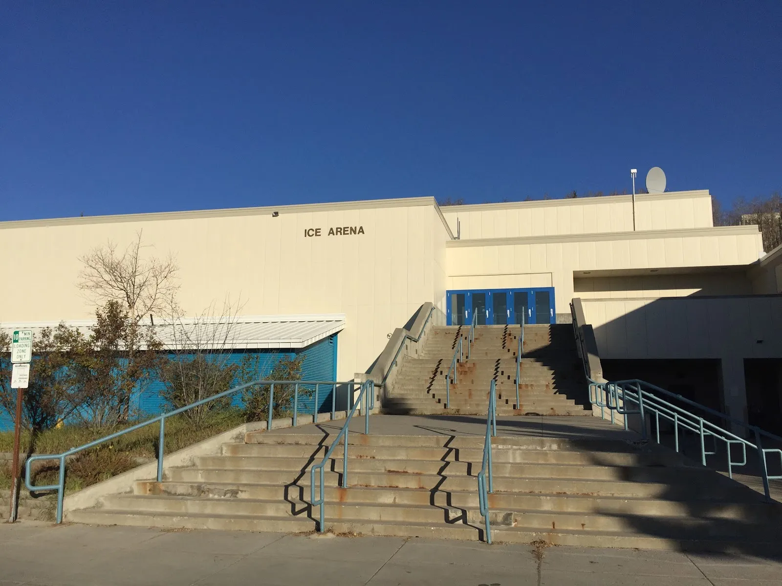 The Patty Center's Ice Arena entrance, with its blue doors at the top of a concrete stairway under the ICE ARENA lettering. — Patty Ice Arena