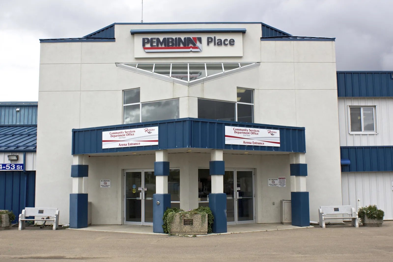 The white-and-blue entrance block with the Pembina Place sign above a pillared canopy marked Arena Entrance and Community Services Department Office. — Pembina Place
