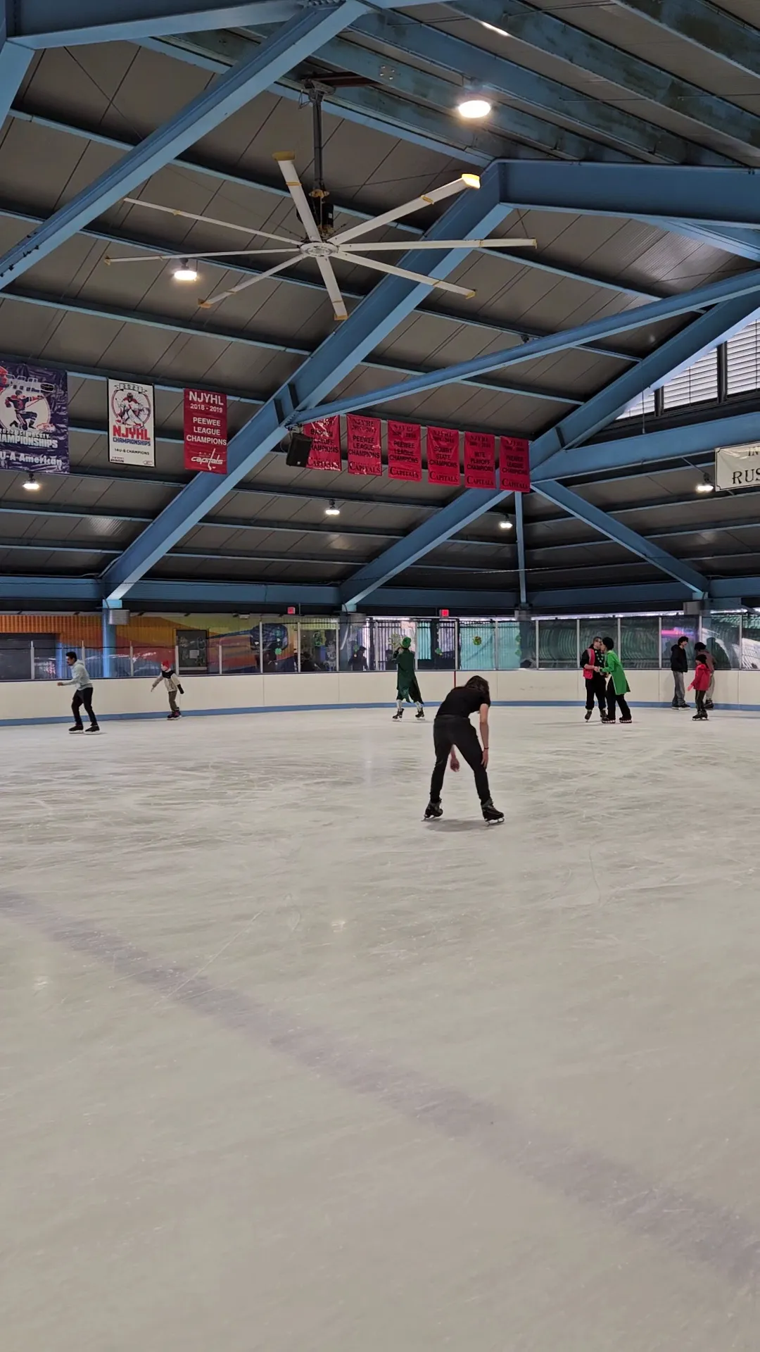 Patinadores en el hielo de la pista Charlie Heger bajo su techo de acero — Charlie Heger Ice Rink at Pershing Field