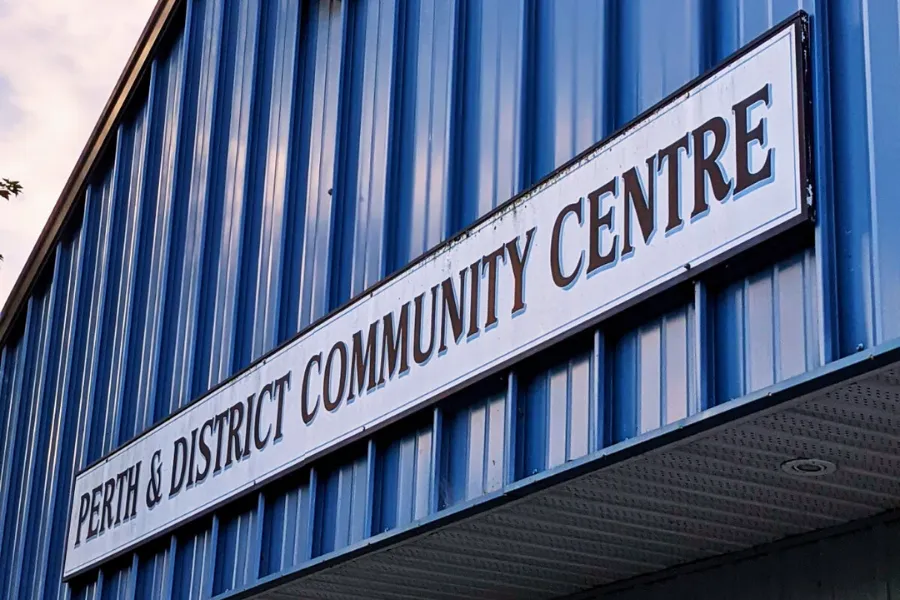 El letrero del Perth & District Community Centre sobre el revestimiento de metal azul encima de la entrada. — Perth & District Community Centre
