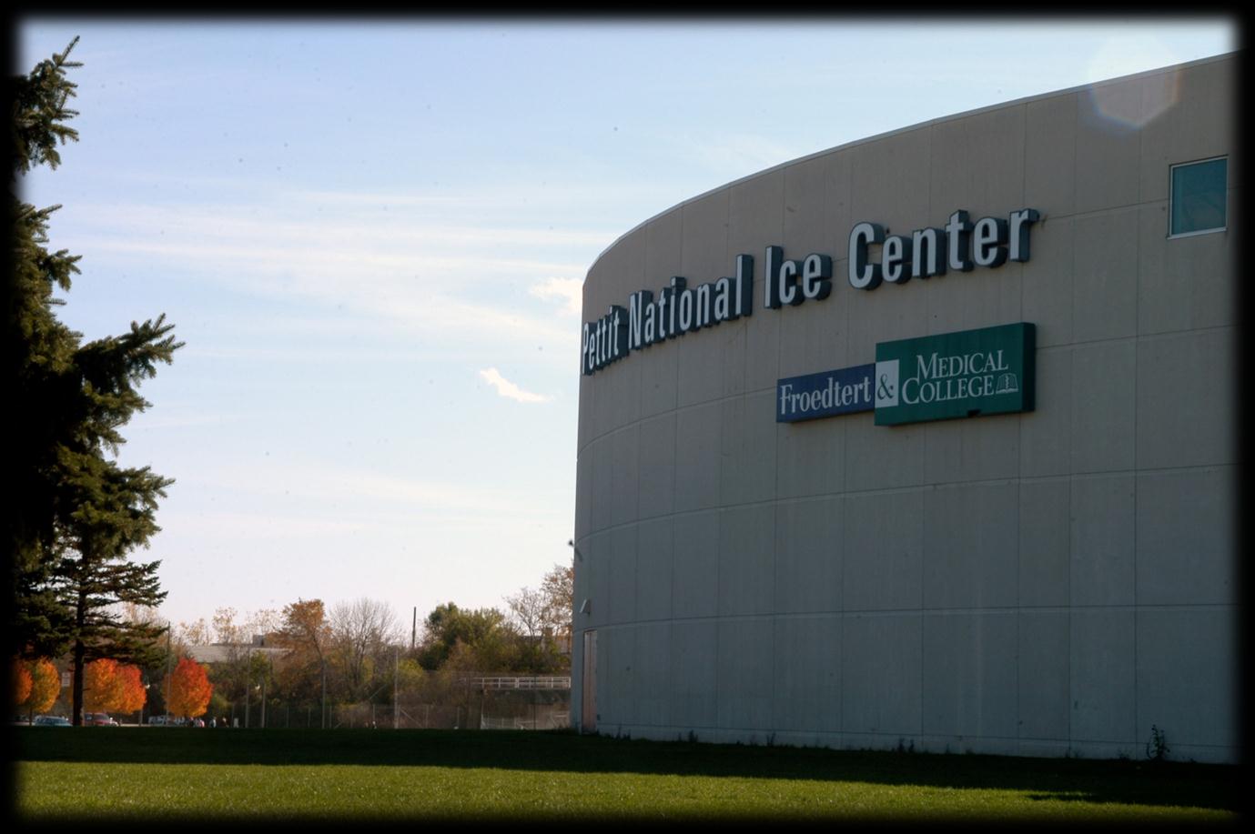 El muro curvo de concreto del Pettit National Ice Center, con su nombre en grandes letras sobre un letrero de Froedtert & Medical College. — Pettit National Ice Center