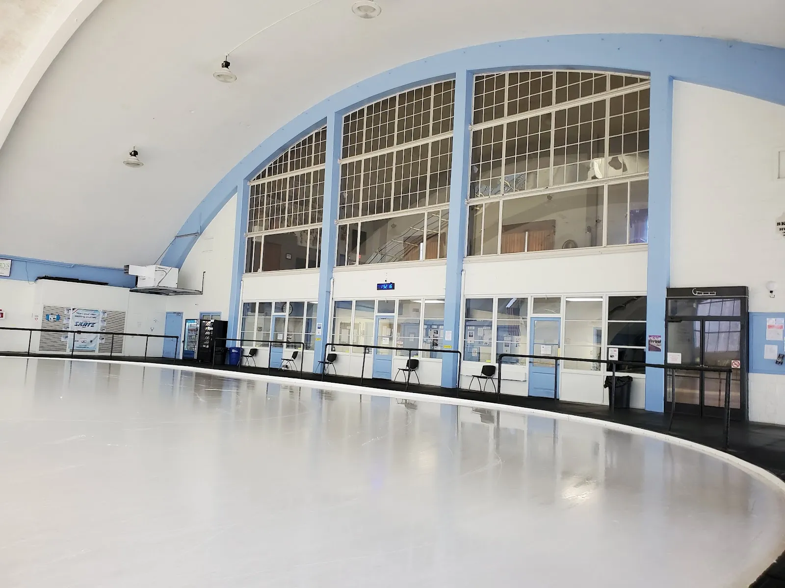 The empty ice of the Philadelphia Skating Club's arched hall with tall windows and the viewing gallery along one side. — Philadelphia Skating Club and Humane Society