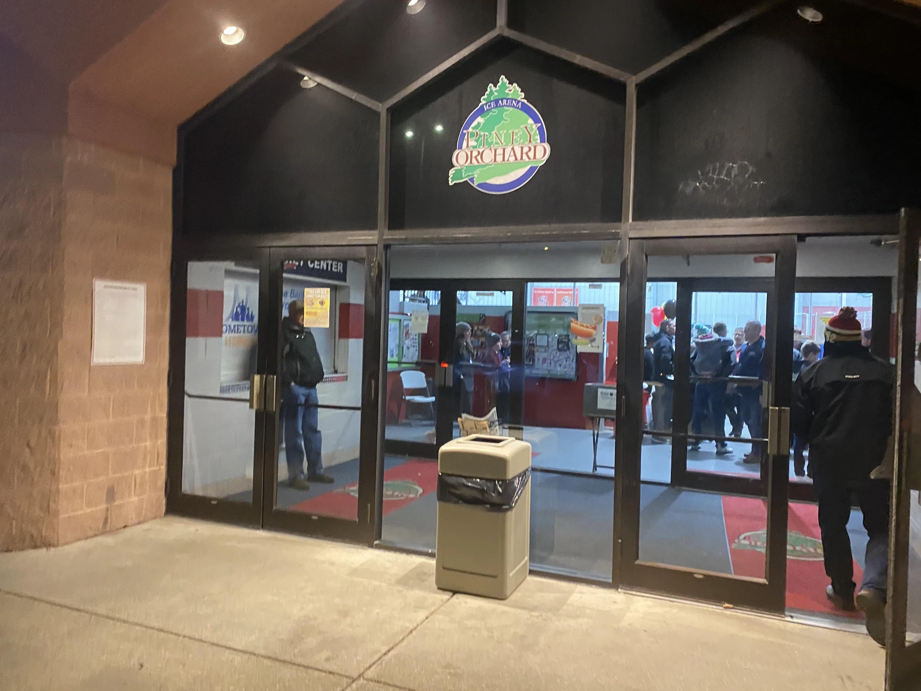 La entrada pública con letrero de Piney Orchard Ice Arena de noche. — Piney Orchard Ice Arena