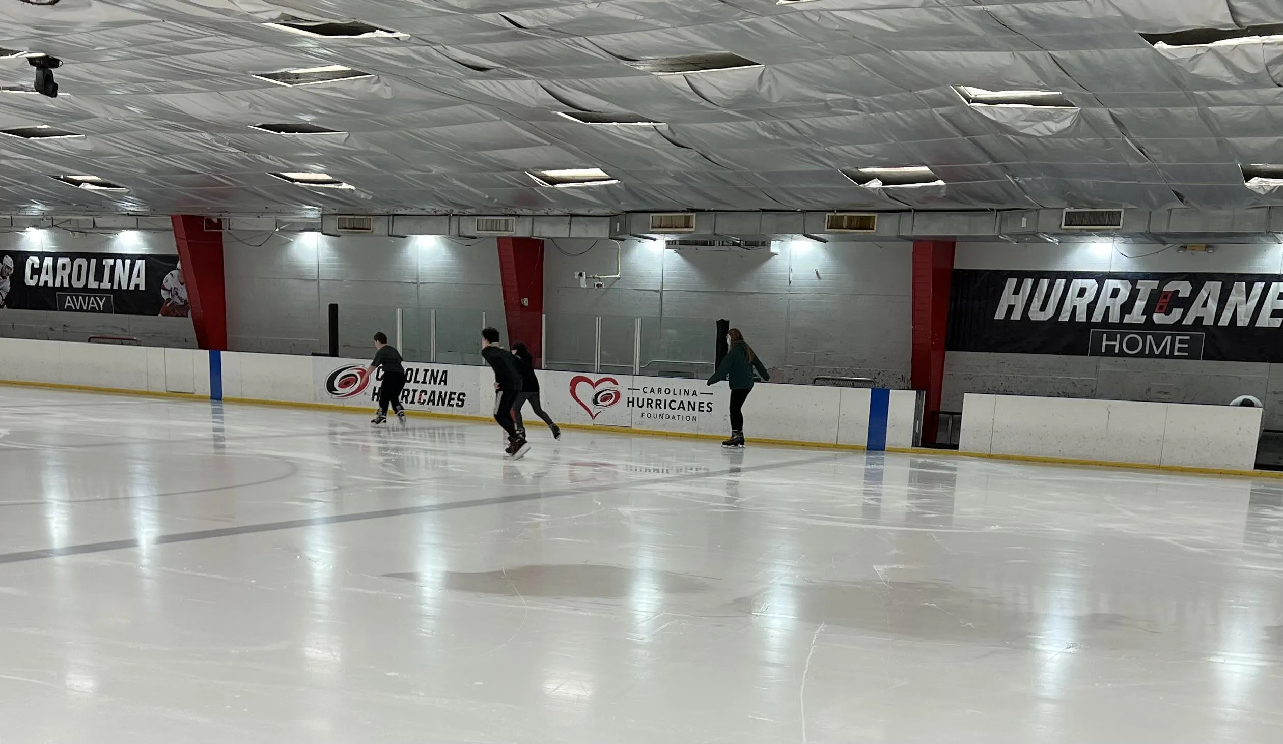Skaters circling below the Hurricanes wall banners — Polar Ice Cary