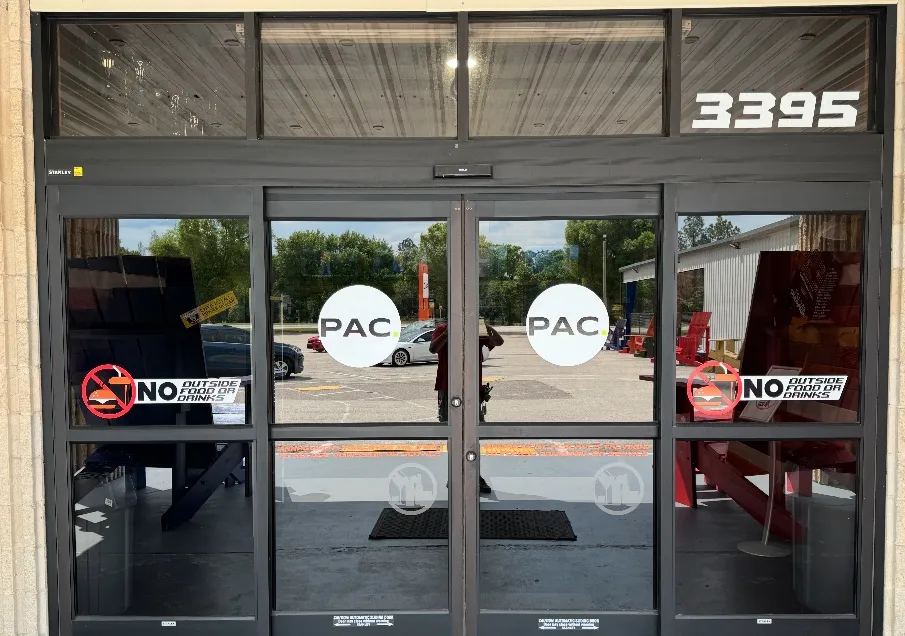 The glass entrance doors of the Polk Athletic Complex with the street number 3395 above the doors and the arena's PAC decals on the glass. — Polk Athletic Complex (Lakeland)