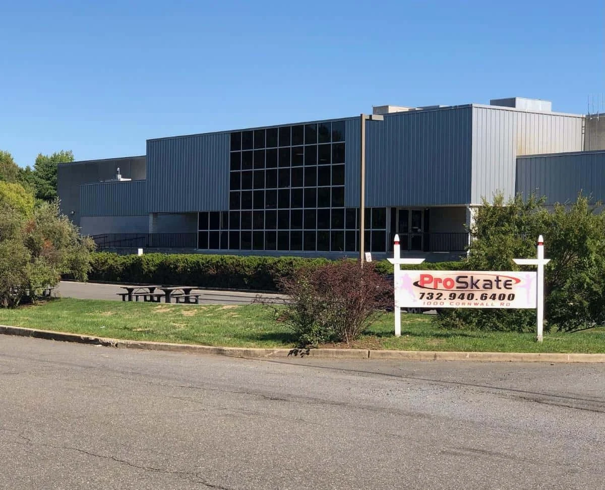 ProSkate's tall glass-fronted building and roadside arena sign. — Pro Skate