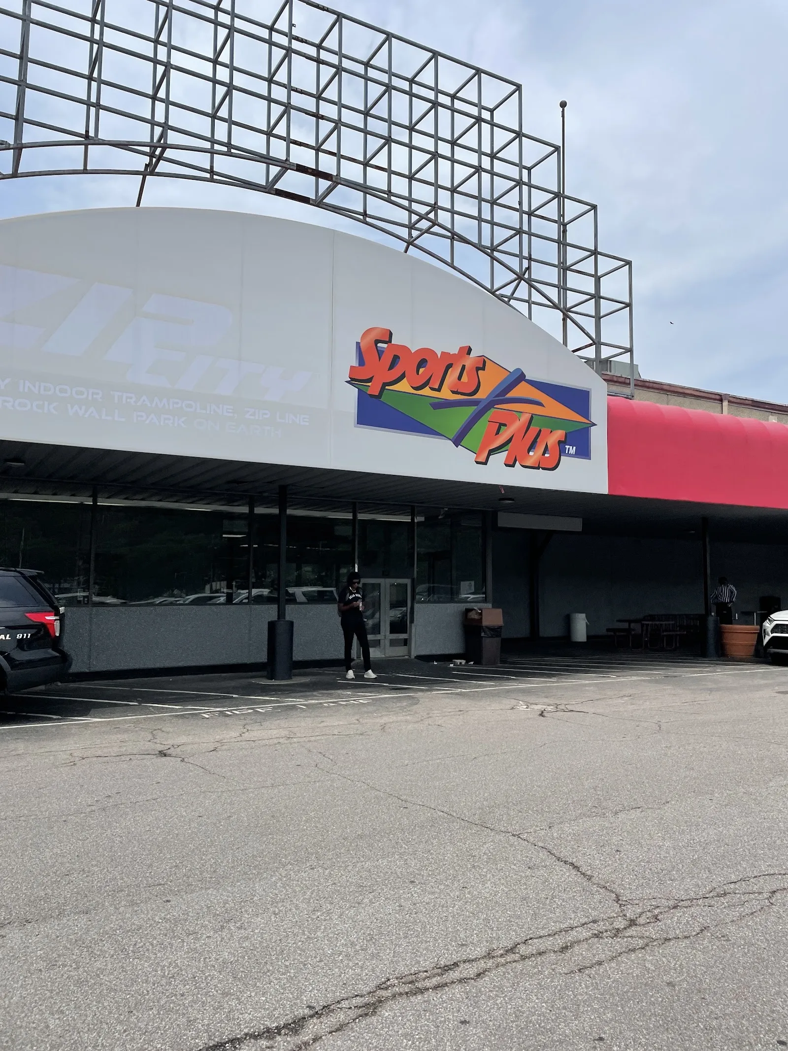 La fachada en arco del edificio Queen City Sportsplex en Cincinnati, que aún conserva el letrero de Sports Plus sobre la entrada de vidrio — Queen City Sportsplex