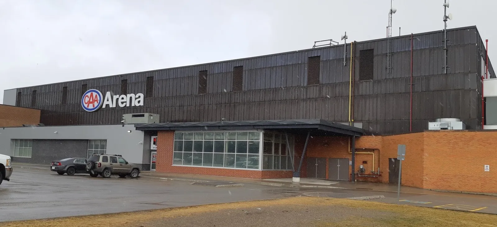 The CAA Arena side of the Quinte Sports & Wellness Centre, with its glass entrance, brick base and the CAA Arena sign, in 2019. — Quinte Sports & Wellness Centre