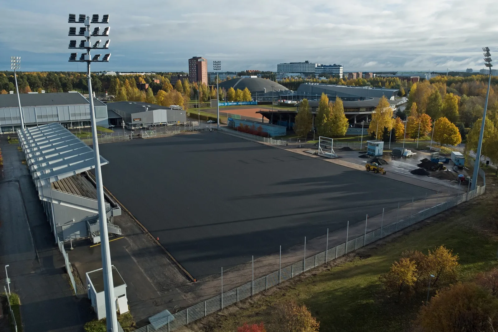 Konstisbanan Raksila i Uleåborg uppifrån på hösten, med läktare och strålkastare – Raksilan tekojääkenttä