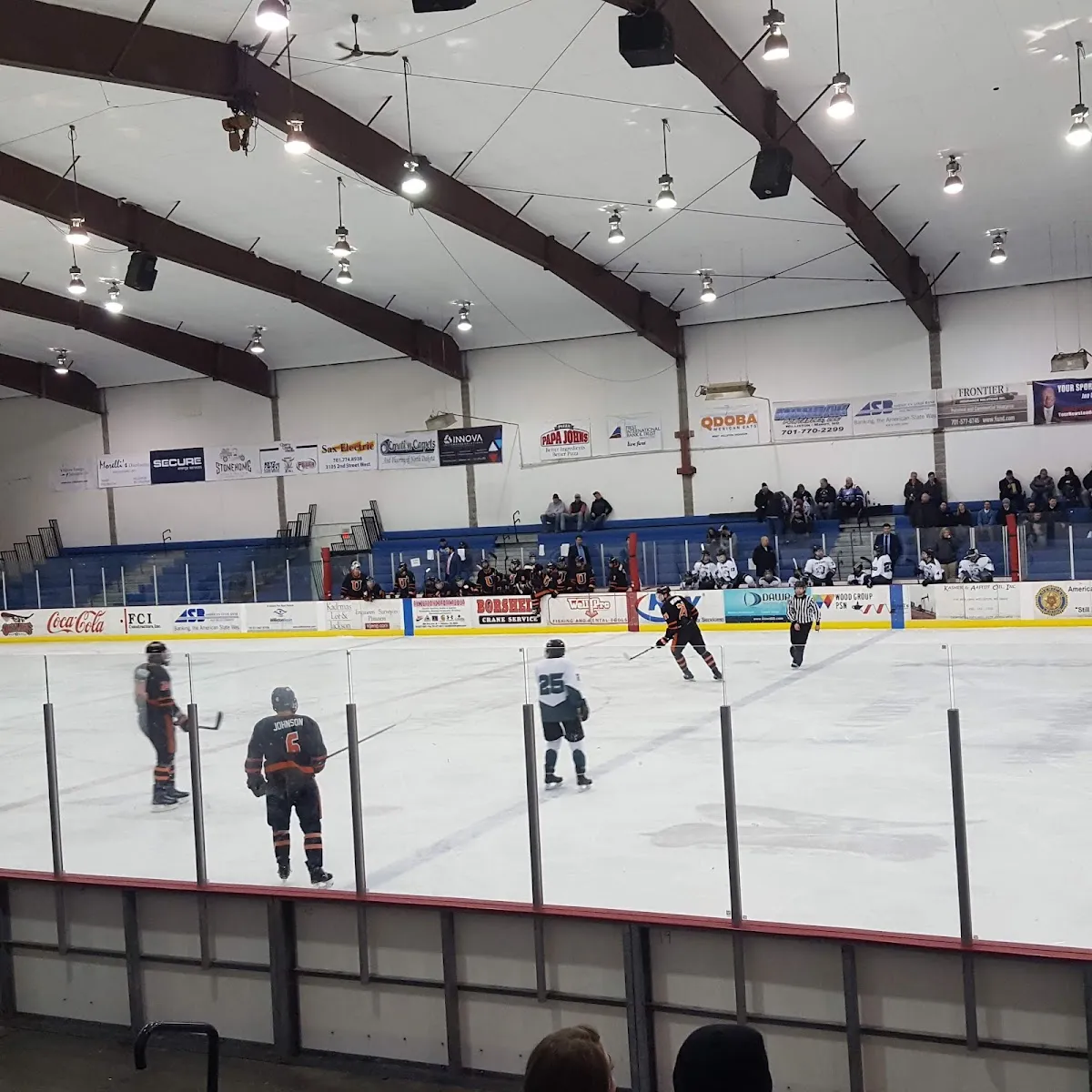 A hockey game on the ice at the Raymond Family Community Center, players spread across the sheet — Raymond Family Community Center