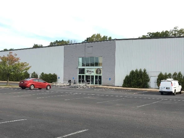 Revolution Ice Gardens’ front entrance and parking area, photographed before the 2019 parking-lot improvements. — Revolution Ice Garden
