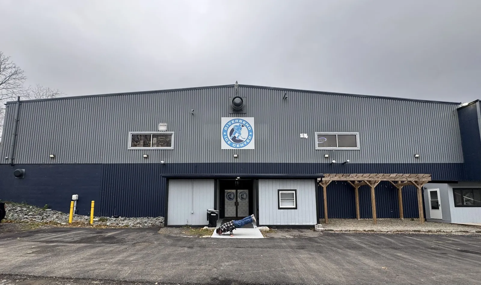 Front of Riverbend Ice Center on River Road with the entrance doors and club badge — Riverbend Ice Center