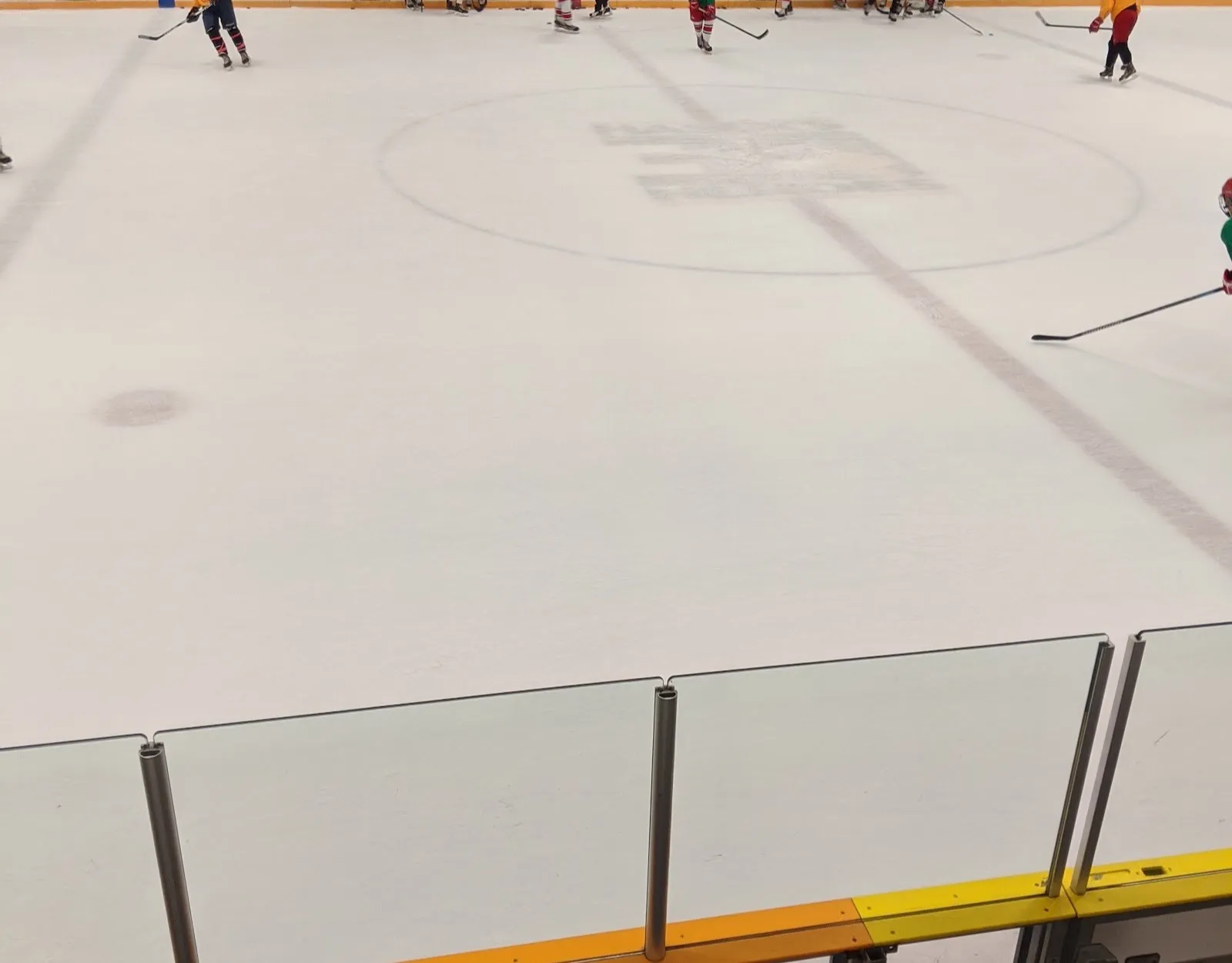 El centro del hielo en la pista Riverside, visto desde las gradas, con el muro de la fama de Bud Bakewell en el muro del fondo — Riverside Ice Rink