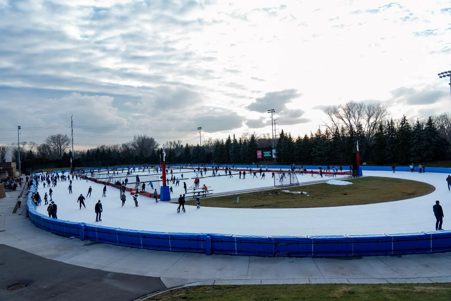Wide view at dusk of the whole outdoor refrigerated oval — Roseville Parks and Recreation