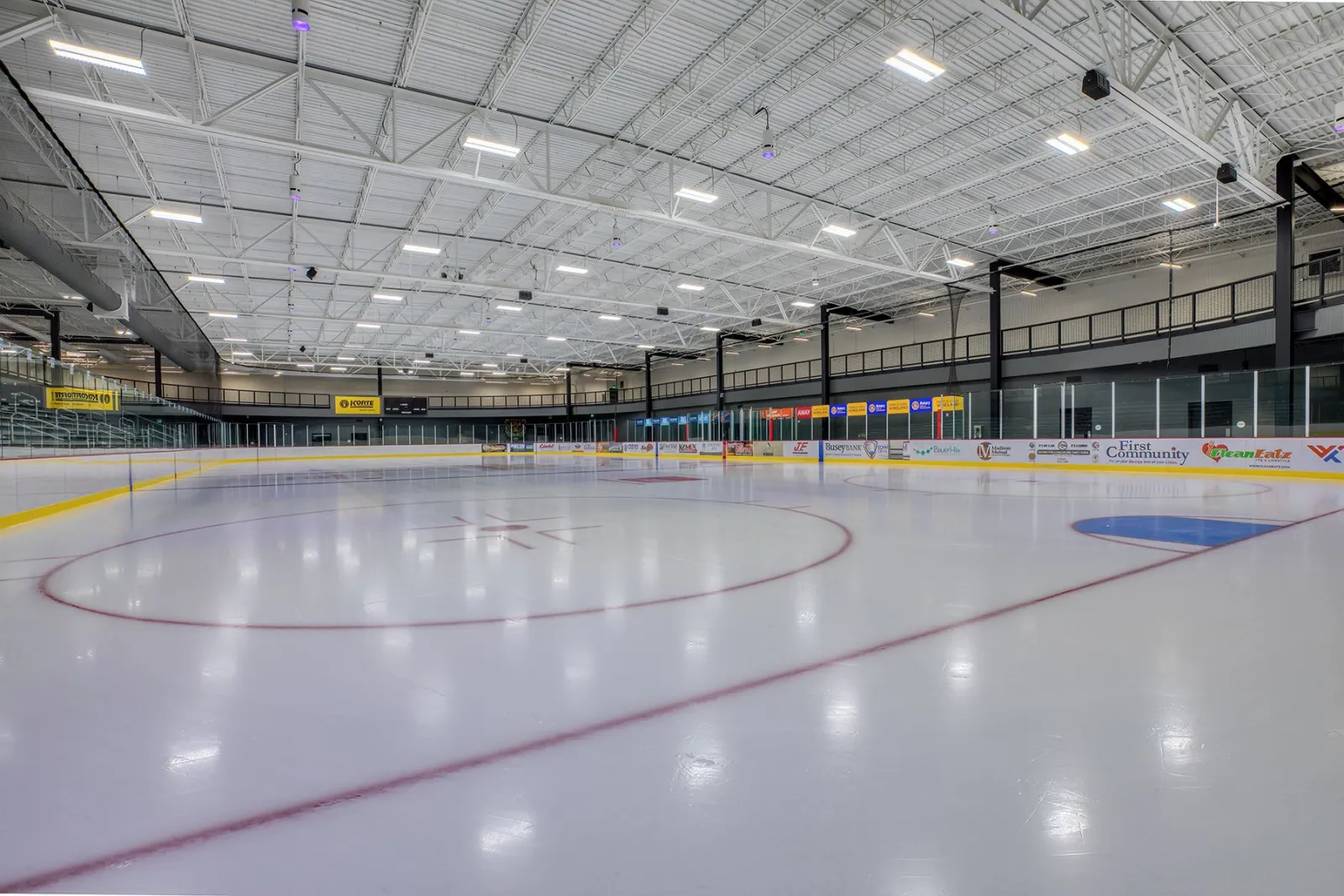 Anuncios de patrocinadores alrededor del hielo vacío bajo armaduras de acero — R.P. Lumber Center