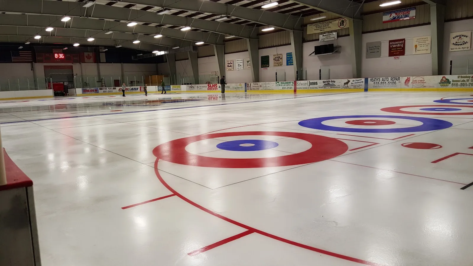 The ice sheet at the Saranac Lake Civic Center with the hockey boards and the curling circles marked on the ice — Saranac Lake Civic Center