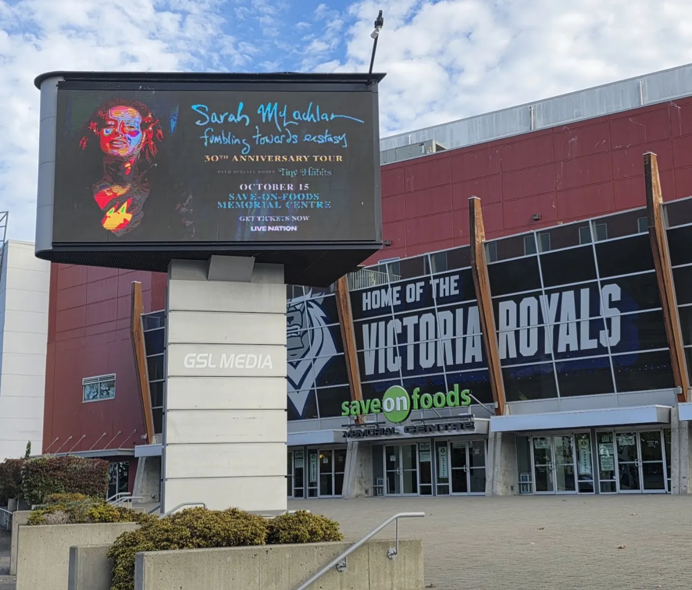 The red-clad front of the Save-On-Foods Memorial Centre with its Home of the Victoria Royals lettering and an electronic sign on a stone pylon. — Save-On-Foods Memorial Centre